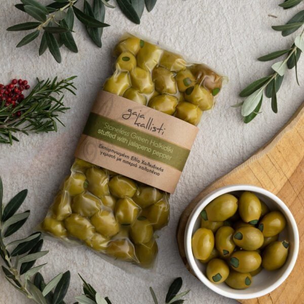 Ontpitte groene Halkidiki olijven gevuld met jalapeno in een verpakking en kom